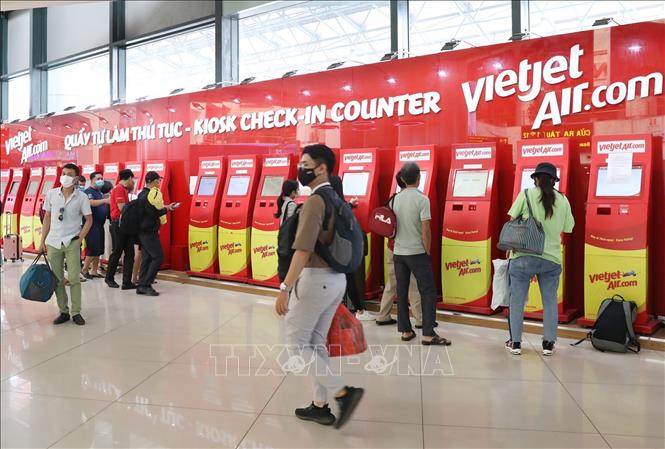 Trong ảnh: Khách hàng làm thủ tục lên máy bay tại các kiosk (check-in tự động) của VietJetAir tại sân bay quốc tế Nội Bài (Hà Nội). Ảnh: Ngọc Hà - TTXVN