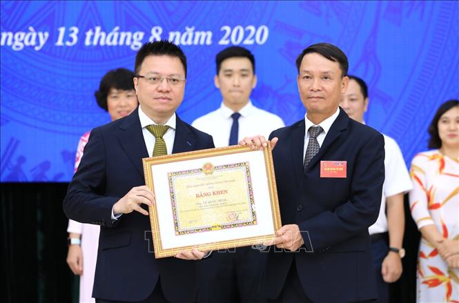 Trong ảnh: Tổng Giám đốc TTXVN Nguyễn Đức Lợi trao tặng Bằng khen cho Phó Tổng Giám đốc Lê Quốc Minh. Ảnh: Doãn Tấn - TTXVN