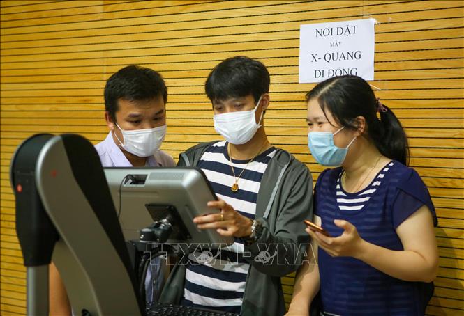 Trong ảnh: Nhân viên y tế đang được tập huấn sử dụng thiết bị chụp X - Quang di động trong bệnh viện dã chiến. Ảnh: Trần Lê Lâm - TTXVN