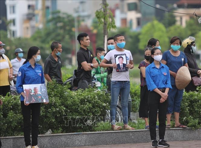 Photo: People line the streets where the hearse carrying former Party leader Le Kha Phieu passes by. VNA Photo