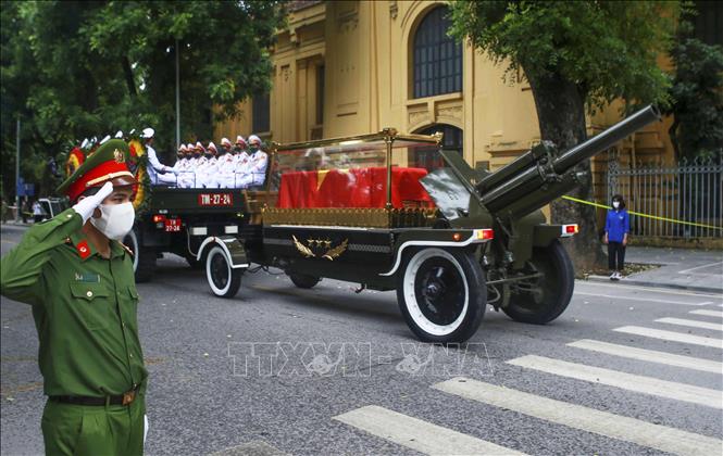 Photo: A policeman pays his respect to the former Party leader Le Kha Phieu when his hearse moves on Le Thanh Tong street. VNA Photo  