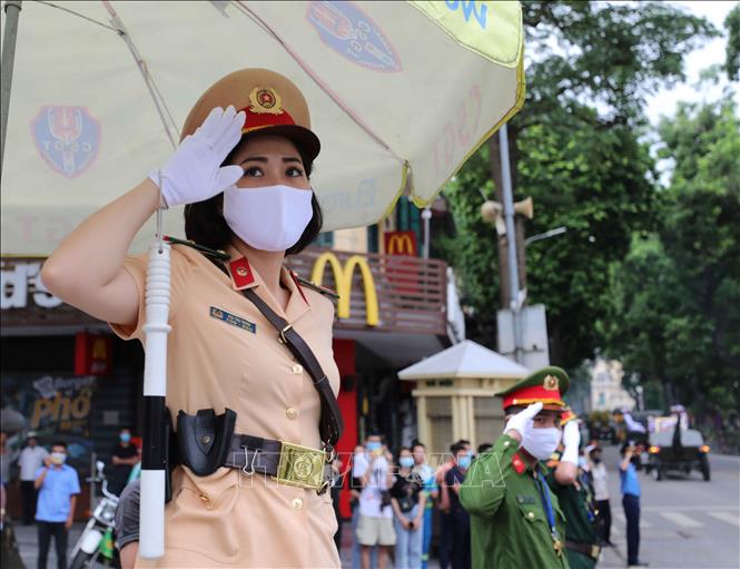 Photo: Policemen pay their respect to the former Party leader Le Kha Phieu when his hearse moves on Le Thanh Tong street. VNA Photo  
