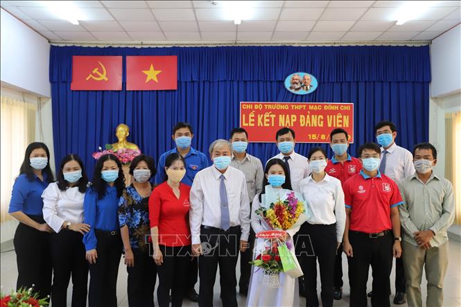 Trong ảnh: Em Giang Thị Mộng Như cùng đại diện Ban giám hiệu nhà trường, Ban Chấp hành Thành đoàn Thành phố Hồ Chí Minh và Quận đoàn Quận 6 tại Lễ kết nạp Đảng. Ảnh: Hồng Giang - TTXVN