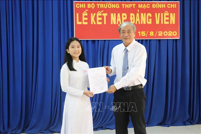 Trong ảnh: Trao quyết định kết nạp Đảng cho em Giang Thị Mộng Như. Ảnh: Hồng Giang - TTXVN.