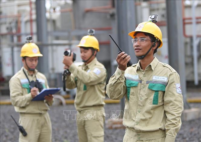 Trong ảnh: Đảng viên Nguyễn Hải Đăng (phải) trao đổi nghiệp vụ trong vận hành, kiểm tra thiết bị trạm biến áp. Ảnh: Ngọc Hà - TTXVN