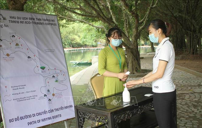 Trong ảnh: Du khách được đo thân nhiệt và sát khuẩn tay khi tham gia dịch vụ chèo thuyền Kayak ở Tràng An. Ảnh: Thùy Dung - TTXVN