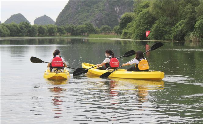 Photo: Tourists go kayaking in Trang An Complex. VNA Photo: Thùy Dung