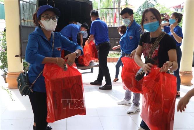 Trong ảnh: Vận chuyển các suất quà tặng người dân vùng dịch Trực Trì, Quốc Tuấn, Nam Sách. Ảnh: Mạnh Minh - TTXVN