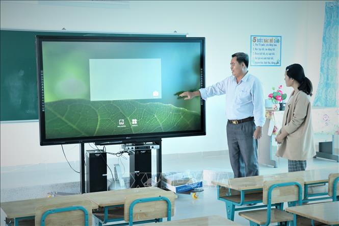 Trong ảnh: Hiệu trưởng trường Tiểu học - Trung học Cơ sở Tân Thành Nguyễn Vọng Xuân giới thiệu về hiệu quả của ti vi thông minh trong dạy và học. Ảnh: Đức Hạnh - TTXVN