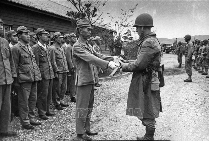 Trong ảnh: Sỹ quan Nhật trao kiếm của mình khi ra trình diện đầu hàng quân Đồng minh. Hành động này thể hiện sự khuất phục trước đối phương, đồng nghĩa với việc họ chấp nhận đầu hàng. Ảnh: Tư liệu quốc tế/TTXVN phát