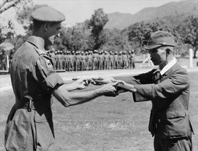 Trong ảnh: Sỹ quan Nhật trao kiếm của mình khi ra trình diện đầu hàng quân Đồng minh. Hành động này thể hiện sự khuất phục trước đối phương, đồng nghĩa với việc họ chấp nhận đầu hàng. Ảnh: Tư liệu quốc tế/TTXVN phát