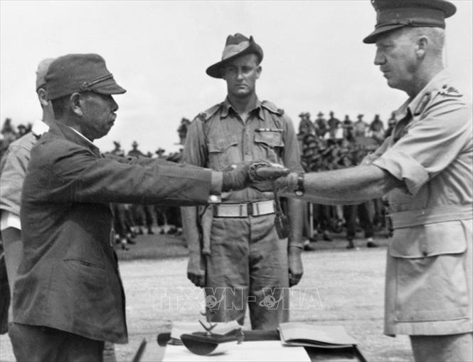 Trong ảnh: Chỉ huy của Tập đoàn quân 18 Nhật Bản tại New Guinea, tướng Hatazo Adachi giao nộp kiếm cho chỉ huy Sư đoàn 6 Australia, tướng Horace Robertson (9/1945). Ảnh: Tư liệu quốc tế/TTXVN phát