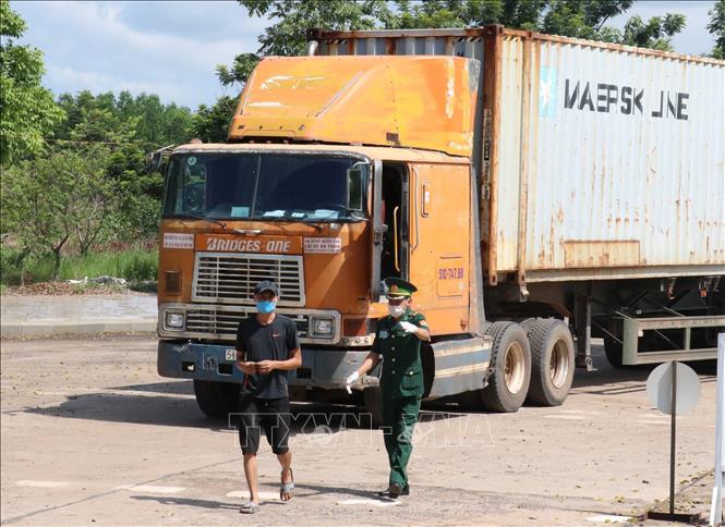 Trong ảnh: Lực lượng bộ đội biên phòng yêu cầu tài xế xe đầu kéo vào khai báo y tế trước khi qua cửa khẩu. Ảnh: Sỹ Tuyên – TTXVN