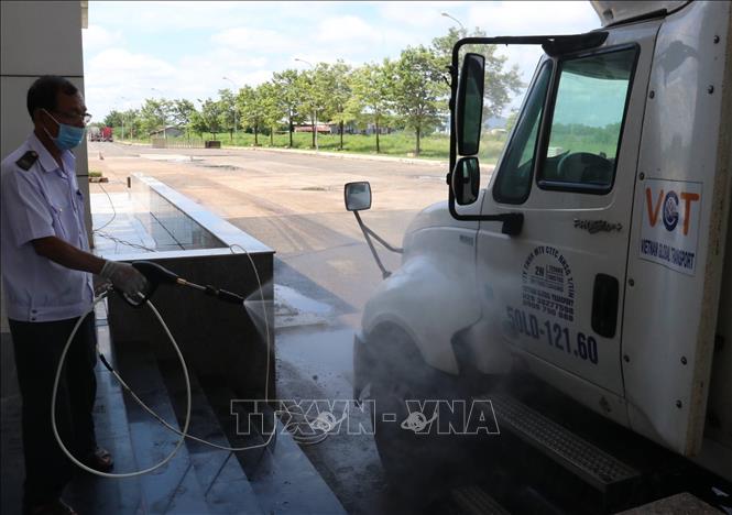 Trong ảnh: Lực lượng kiểm soát tại cửa khẩu quốc tế Hoa Lư phun xịt khử khuẩn xe đầu kéo trước khi cho qua biên giới. Ảnh: Sỹ Tuyên – TTXVN