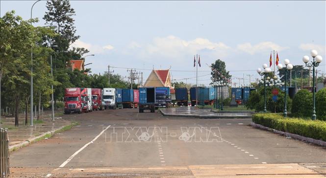 Trong ảnh: Xe đầu kéo container chờ nhận hàng tại khu vực cột mốc 69 biên giới Việt Nam –Campuchia. Ảnh: Sỹ Tuyên – TTXVN