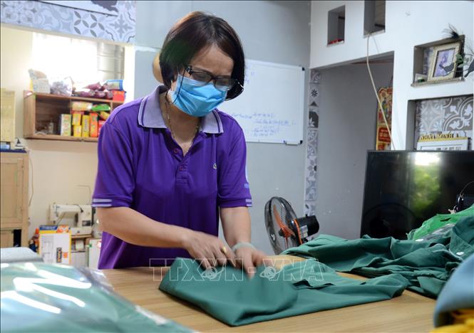 Trong ảnh: Chị Nguyễn Thị Thu Nga, Chi hội trưởng Chi hội phụ nữ số 15 (phường Hòa Thọ Đông, quận Cẩm Lệ, thành phố Đà Nẵng) gấp các bồ đồ thành phẩm. Ảnh: Quốc Dũng – TTXVN