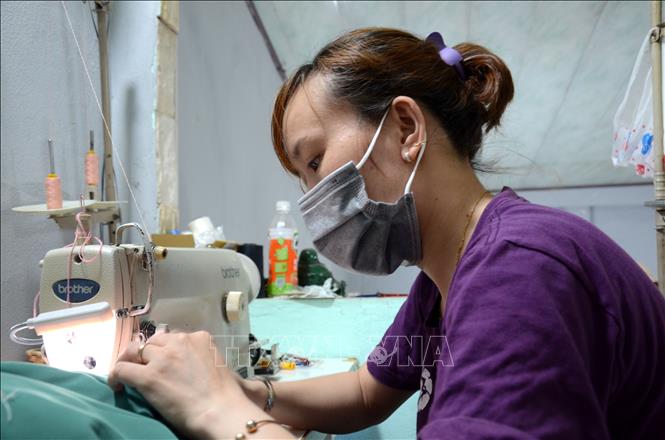 Trong ảnh: Để có được những bộ quần áo bền đẹp tặng các bác sỹ, các cô, các chị trong Hội phụ nữ đã chăm chỉ làm việc từ 7 giờ sáng đến 6, 7 giờ tối hàng ngày. Ảnh: Quốc Dũng – TTXVN