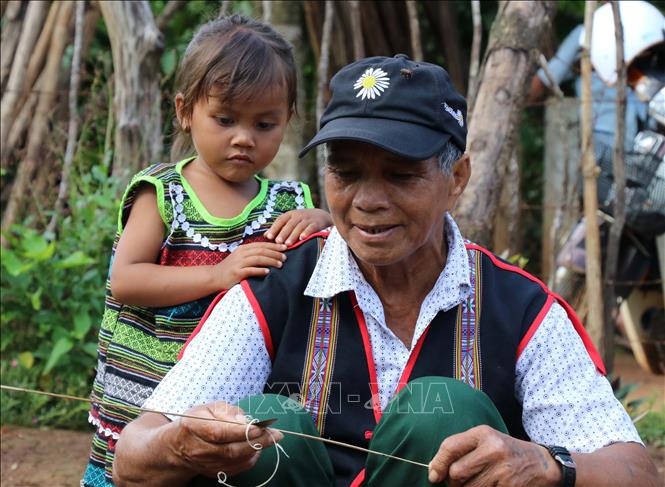 Trong ảnh: Các cháu bé chăm chú nhìn theo công đoạn làm gùi của ông mình. Ảnh: Hồng Điêp - TTXVN 