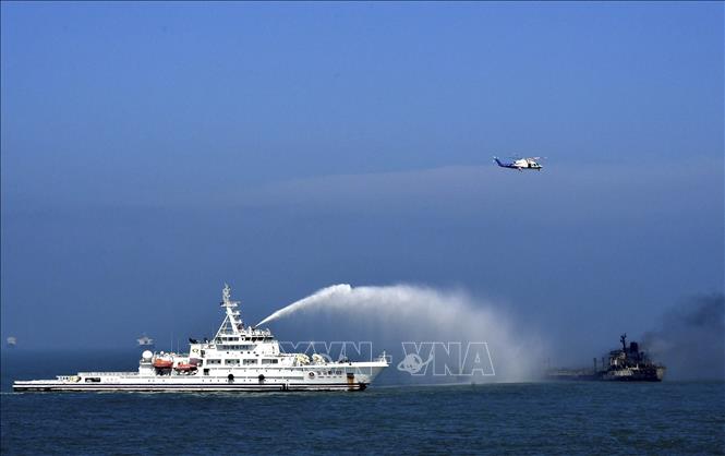 Trong ảnh: Tàu cứu hộ dập lửa trên tàu chở dầu bị cháy sau khi va chạm với tàu chở hàng gần cửa sông Dương Tử ngày 20/8/2020. Ảnh: THX/TTXVN 