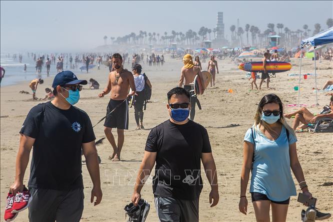 Trong ảnh: Người dân tránh nắng nóng trên bãi biển Huntington ở California (Mỹ) ngày 25/4/2020. Ảnh: AFP/TTXVN