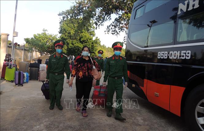 Trong ảnh: Cán bộ Trung tâm huấn luyện giúp công dân chuyển tư trang lên xe để trở về địa phương sau thời gian hết cách ly y tế tập trung. Ảnh: Công Thử - TTXVN