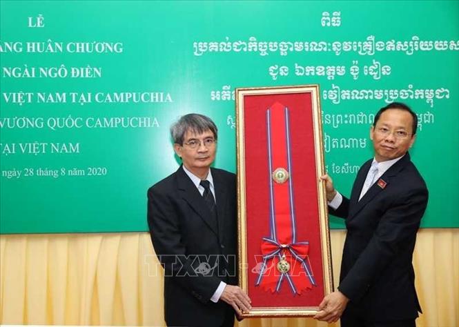 Trong ảnh: Đại sứ đặc mệnh toàn quyền Campuchia tại Việt Nam Chay Navuth (bên phải) trao tượng trưng Huân chương Hữu nghị Sahametrei hạng Mahasena của Campuchia cho gia đình cố Đại sứ Ngô Điền. Ảnh: TTXVN phát