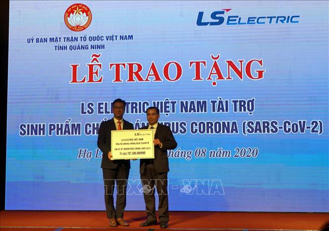 Trong ảnh : Đại diện Công ty TNHH LS Electric Việt Nam (một đơn vị thành viên của Tập đoàn LS ELECTRIC, Hàn Quốc) (bên trái) trao tặng tỉnh Quảng Ninh 1.500 bộ sinh phẩm chuẩn đoán xét nghiệm vi rút SARS-CoV-2.  Ảnh: Bùi Đức Hiếu - TTXVN