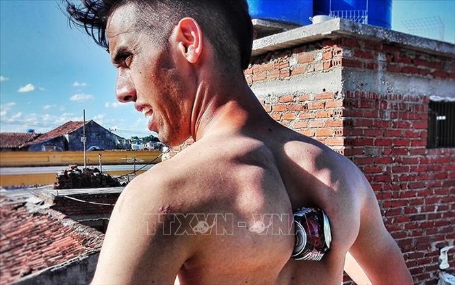 Trong ảnh: Chàng trai Cristian Manuel Castellano Rángel của Cuba lập kỷ lục Guinness khi chỉ sử dụng xương bả vai để bóp vỡ 84 lon bia trong vòng 60 giây. Ảnh: Diario de Cuba/ TTXVN