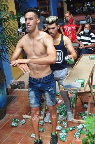 Trong ảnh: Chàng trai Cristian Manuel Castellano Rángel của Cuba lập kỷ lục Guinness khi chỉ sử dụng xương bả vai để bóp vỡ 84 lon bia trong vòng 60 giây. Ảnh: OnCuba News/ TTXVN