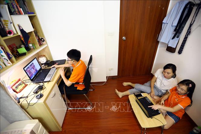Trong ảnh: Gia đình chị Trần Thúy Hằng tại Cầu Giấy có 2 con đều học tại trường Tiểu học và Trung học cơ sở FPT, hôm nay cùng dự lễ khai giảng trực tuyến. Ảnh: Huy Hùng - TTXVN 