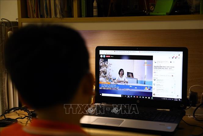 Trong ảnh: Học sinh Chử An Nam lớp 7A7 trường Tiểu học và Trung học Cơ sở FPT Cầu Giấy trao đổi với cô giáo trước giờ khai giảng. Ảnh: Huy Hùng - TTXVN