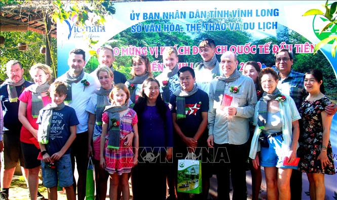 Trong ảnh: Lễ đón đoàn khách quốc tế đầu tiên đến tham quan điểm du lịch homestay Út Trinh (xã Hòa Ninh, huyện Long Hồ, tỉnh Vĩnh Long) nhân dịp Tết Dương lịch năm 2020. Đây là những vị khách quốc tế đến từ Vương quốc Anh. Ảnh: Thúy Hằng - TTXVN