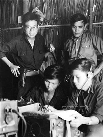 Trong ảnh: Nhà báo Lâm Tấn Tài (người đứng bìa phải) đang theo dõi truyền tin bài về cứ tại một tổ phóng viên TTXGP tác nghiệp tại vùng ven Sài Gòn trươc cuộc Tổng tiến công và nổi dậy Xuân Mậu Thân 1968. Ảnh: Tư liệu TTXGP