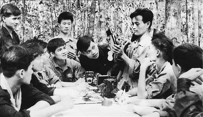 Trong những năm kháng chiến chống Mỹ, VNTTX ở miền Bắc đã chi viện cho chiến trường miền nam hơn 450 cán bộ chủ chốt, phóng viên, biên tập viên, nhân viên kỹ thuật, chưa kể hàng trăm lượt cán bộ, phóng viên, biên tập viên và nhân viên kỹ thuật từ miền bắc theo các mũi tiến quân, tham gia các chiến dịch ở khắp các chiến trường miền Nam, Lào, Campuchia; trong đó tiêu biểu nhất là lớp phóng viên chiến trường GP10. Trong ảnh: Bồi dưỡng nghiệp vụ ảnh báo chí cho các phóng viên tại căn cứ TTXGP. Ảnh: Tư liệu VNTTX