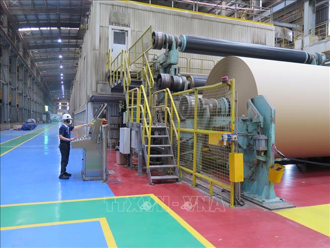 Trong ảnh: Công nhân điều khiển dây chuyền sản xuất giấy bao bì tại Công ty TNHH Giấy Vina Kraft trong Khu công nghiệp Mỹ Phước 3, thị xã Bến Cát, tỉnh Bình Dương. Ảnh: Minh Hưng-TTXVN                 