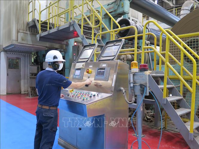 Trong ảnh: Công nhân điều khiển dây chuyền sản xuất giấy bao bì tại Công ty TNHH Giấy Vina Kraft trong Khu công nghiệp Mỹ Phước 3, thị xã Bến Cát, tỉnh Bình Dương. Ảnh: Minh Hưng-TTXVN         