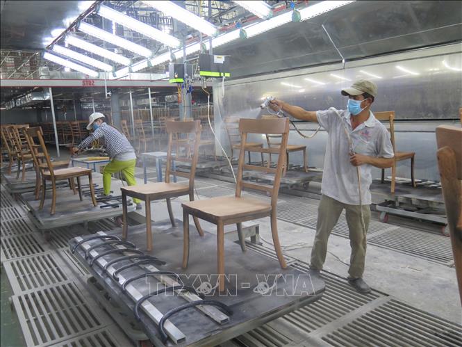 Trong ảnh: Công nhân công ty Triệu Phú Lộc phun sơn cho lô ghế xuất khẩu vào thị trường châu Âu. Ảnh: Minh Hưng-TTXVN