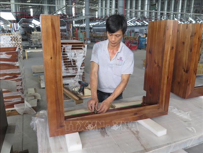 Trong ảnh: Sản xuất đồ gỗ xuất khẩu tại nhà máy của công ty Triệu Phú Lộc. Ảnh: Minh Hưng-TTXVN                                  
