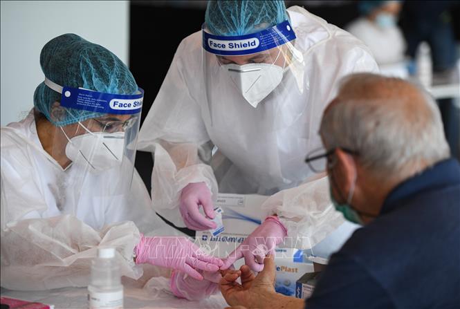 Trong ảnh: Nhân viên y tế lấy mẫu xét nghiệm COVID-19 cho người dân tại Bucharét, Romania, ngày 10/6/2020. Ảnh: AFP/ TTXVN