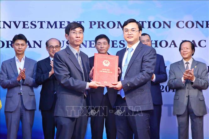 Trong ảnh: Đại diện Ban quản lý Khu Công nghệ cao Hòa Lạc trao giấy chứng nhận đầu tư cho doanh nghiệp, tại Hội nghị xúc tiến đầu tư các doanh nghiệp Hàn Quốc vào Khu Công nghệ cao Hòa Lạc, ngày 7/7/2017. Ảnh: Minh Quyết – TTXVN