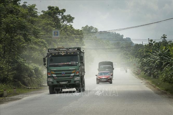 Trong ảnh: Xe trọng tải lớn chở vật liệu xây dựng tạo ra khói bụi mù mịt gây ô nhiễm môi trường, ảnh hưởng sức khỏe người dân chạy trên đường Hồ Chí Minh đoạn gần khu vực Miếu Môn. Ảnh: Trọng Đạt - TTXVN