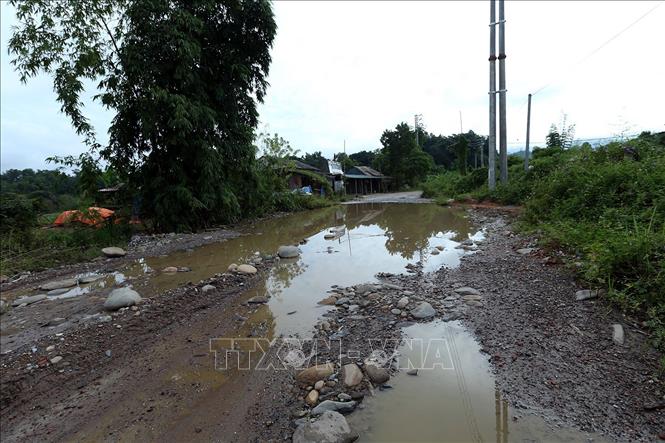 Trong ảnh: Nước mưa đọng lại trên mặt đường thành những vũng nước to, đất đá bị cuốn trôi tràn xuống mặt đường. Ảnh: Phan Tuấn Anh - TTXVN
