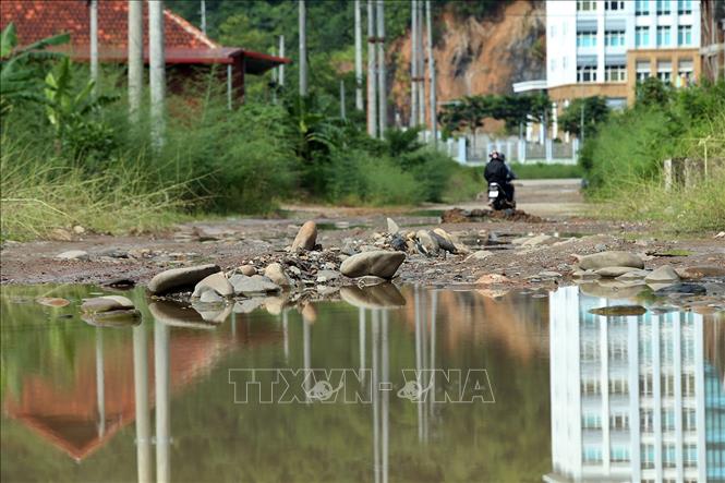 Trong ảnh: Những tảng đá to tràn xuống nằm giữa lòng đường gây khó khăn cho các phương tiện khi đi qua đây. Ảnh: Phan Tuấn Anh - TTXVN