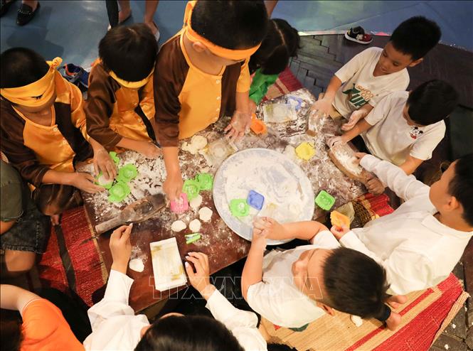 Trong ảnh: Các em nhỏ cùng làm bánh trung thu. Ảnh: Thanh Tùng - TTXVN 