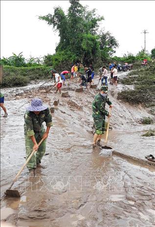 Photo: Soldiers and people in the central province of Quang Tri clean up mud dropped on the roads after the storm. VNA Photo: Hồ Cầu
