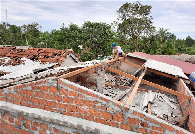 Photo: Locals in the central province of Quang Tri repair their houses after the storm. VNA Photo: Hồ Cầu