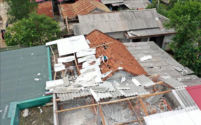 Photo: Locals in the central province of Quang Tri repair their houses after the storm. VNA Photo: Hồ Cầu