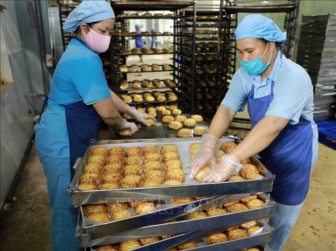 Trong ảnh: Kiểm tra chất lượng bánh trước khi đóng gói tại nhà máy của Công ty. Ảnh: Vũ Sinh - TTXVN