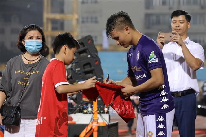 Trong ảnh: Kết thúc trận đấu cầu thủ Nguyễn Quang Hải (CLB Hà Nội) ký tặng người hâm mộ. Ảnh: Minh Quyết - TTXVN