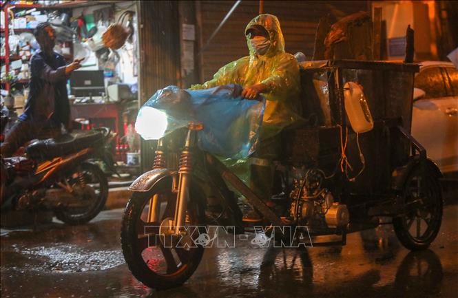 Trong ảnh: Với chiếc xe máy được cải tiến lại để có thể kéo được một xe đẩy rác, người nữ công nhân môi trường này lại len lỏi vào từng ngõ ngách của Thủ đô để thu gom rác về nơi tập kết. Ảnh: Thanh Tùng - TTXVN